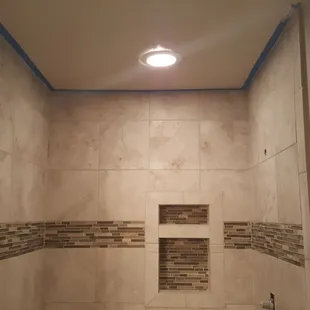 a walk in shower with tiled walls