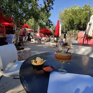 a table with a drink and chips