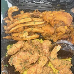 Fried shrimp with the legs and skin still on the shrimp with fries and yams