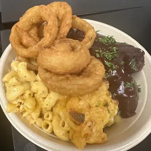 a plate of food with onion rings and macaroni and cheese