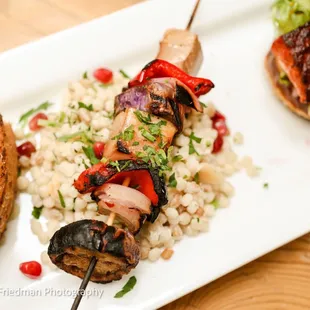 a plate of grilled meat skewers and rice