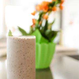 a smoothie and a vase of flowers