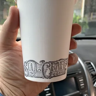 a hand holding a cup of coffee