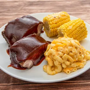 a plate of meat, macaroni and cheese and corn