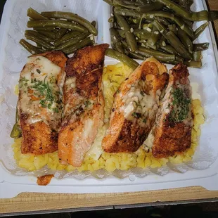 Grilled salmon with a cream sauce over yellow rice, with green beans