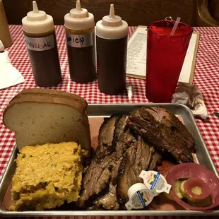 Tender Brisket, great ribs, huge warm cornbread . Cole slaw  behind bread .  Pickle and red onion . Butter .