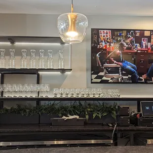 a bar with wine glasses on the counter