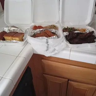 three containers of food on a kitchen counter