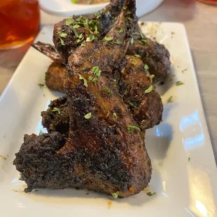 a plate of lamb chops on a table