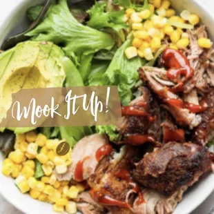 a bowl of chicken, corn, avocado, and lettuce