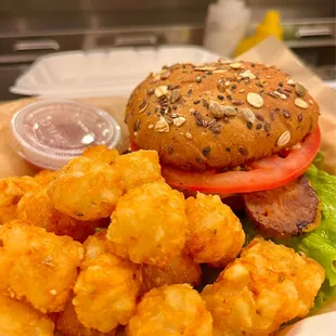 a burger and tater tots on a tray