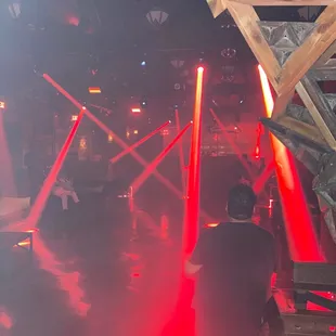 a man standing in front of red lights
