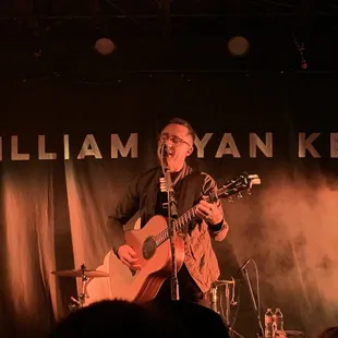 a man playing a guitar on stage