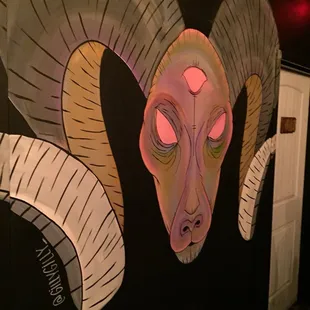 a painting of a ram's head on a wall