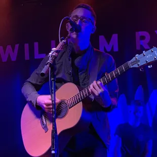 a man playing a guitar on stage
