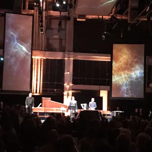 a stage with a man on a piano