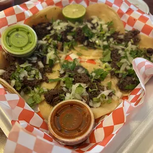 a tray of tacos and salsa