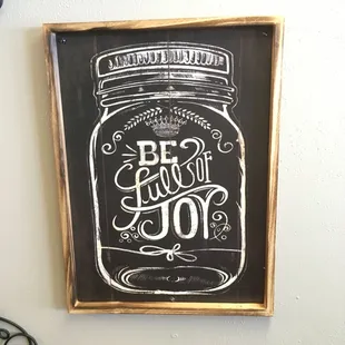 a chalkboard sign with a mason jar on it