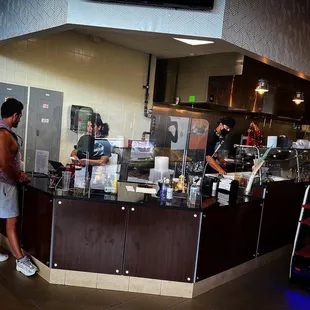 a man standing at a counter in a restaurant