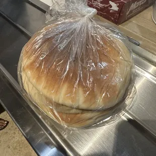 a sandwich wrapped in plastic on a conveyor belt