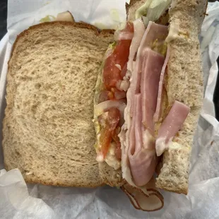 a ham sandwich with lettuce and tomatoes