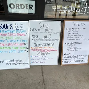 menus on a sidewalk in front of a store