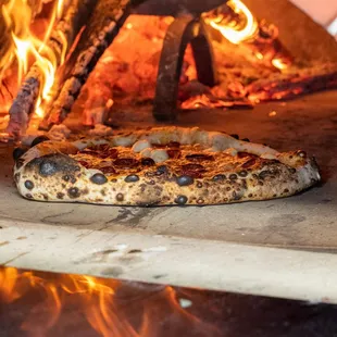 a pizza being cooked in a brick oven