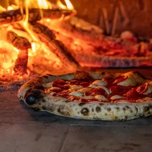 a pizza in front of a fire