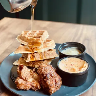 a plate of food with waffles and sauce