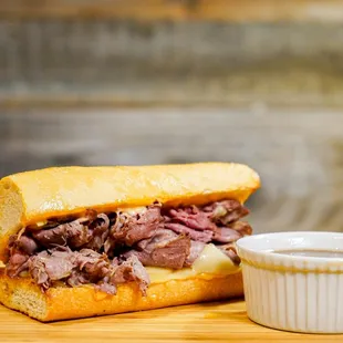 a roast beef sandwich with a side of mustard