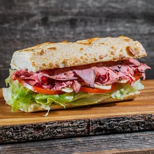 a roast beef sandwich on a cutting board
