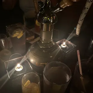a table with drinks and a lit candle