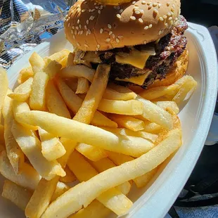 Jumbo Cheeseburger with sautéed onions, lettuce, tomatoes , mayo, mustard and ketchup and fries.