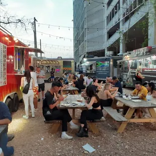 a group of people eating outside of a food truck