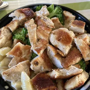 Grilled Chicken on Mac n Cheese bowl. Heavy on chicken, light on broccoli and Alfredo sauce. Really tasty and well cooked pasta.