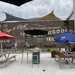 people sitting at picnic tables under umbrellas