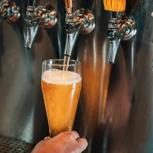 a hand holding a glass of beer