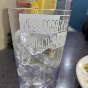 a glass of cold water with lemon wedges