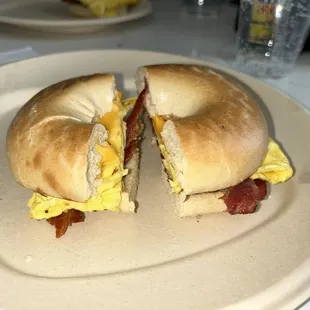 a bagel sandwich with eggs and bacon