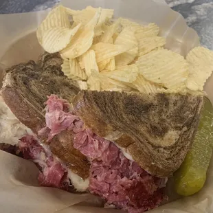 Reuben on marbled rye with ruffles and pickle spear
