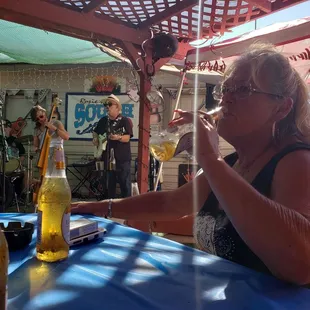 a woman sitting at a table with a glass of beer