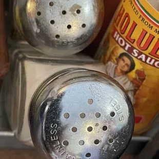 Dirty salt and pepper shakers look like they haven't been cleaned in awhile.