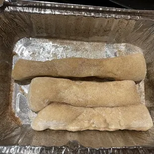 two dough sticks in a foil pan