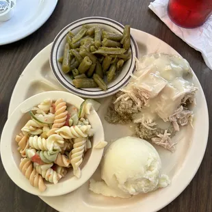 Turkey and dressing with mashed potatoes, green beans, and pasta salad.