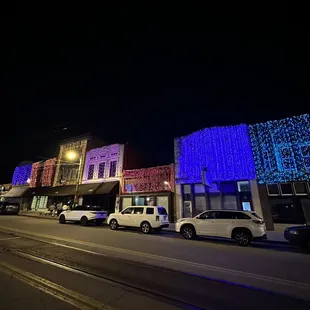 a row of buildings lit up with christmas lights