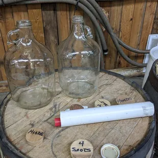 three glass bottles on a barrel
