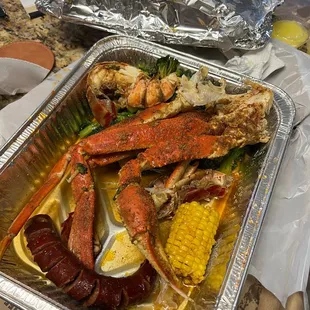 Crab legs, lobster tail, sausage, corn, and broccoli.