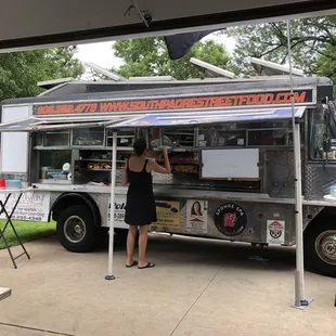 a woman standing in front of a food truck