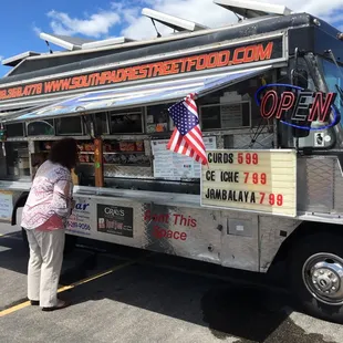 a woman standing in front of a food truck