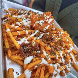 Buffalo fries, fries tossed in buffalo sauce with bacon BLEU cheese and wings